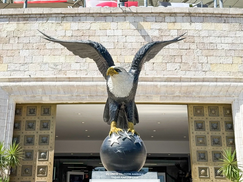 Eine große, stolze Adler-Statue auf einer Weltkugel mit drei Sternen vor dem Eingang eines geschichtsträchtigen Fußballstadions in Istanbul.